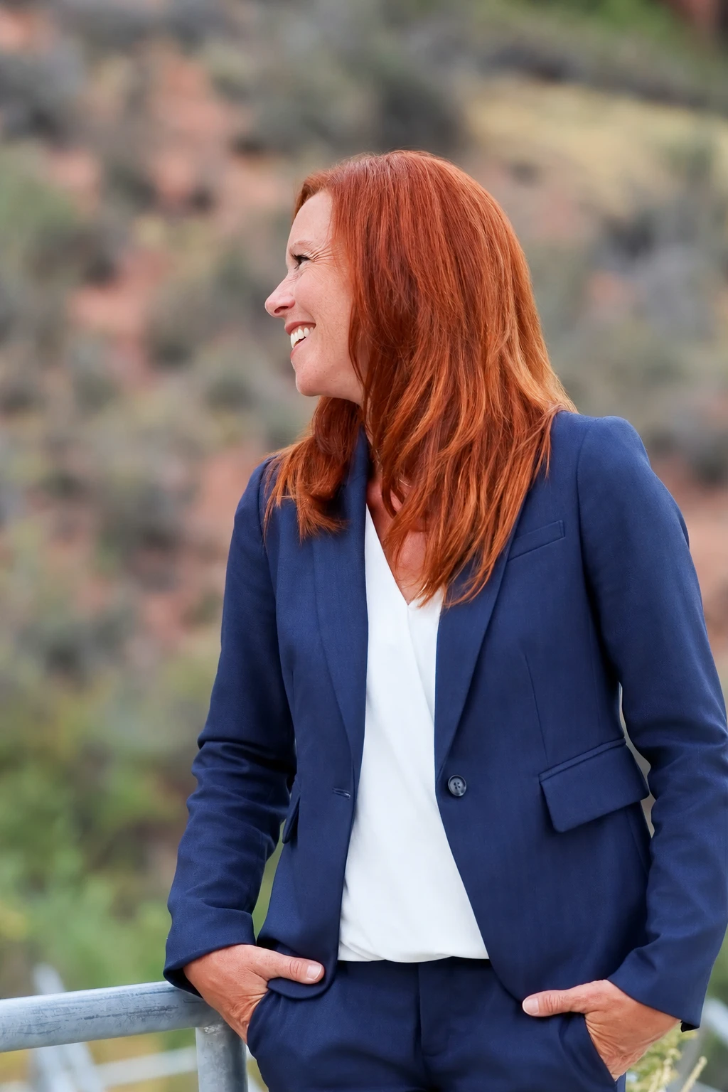 Angela laughing and looking toward the headline, wearing a navy suit